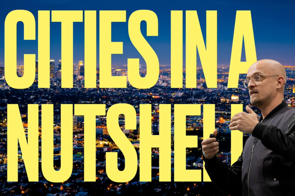 Videostill aus einem Youtube-Beitrag. Zu sehen ist im Hintergrund die Luftaufnahme einer grossen Stadt im Abendlicht. Darüber in grossen gelben Lettern steht "CITIES IN A NUTSHELL". Rechts im Bild als Overlay der Sepaker Christian Hansen.